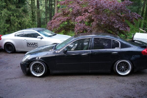 A black car parked in front of another white car.