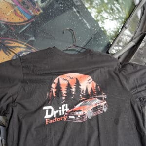 A black shirt with trees and a car on it