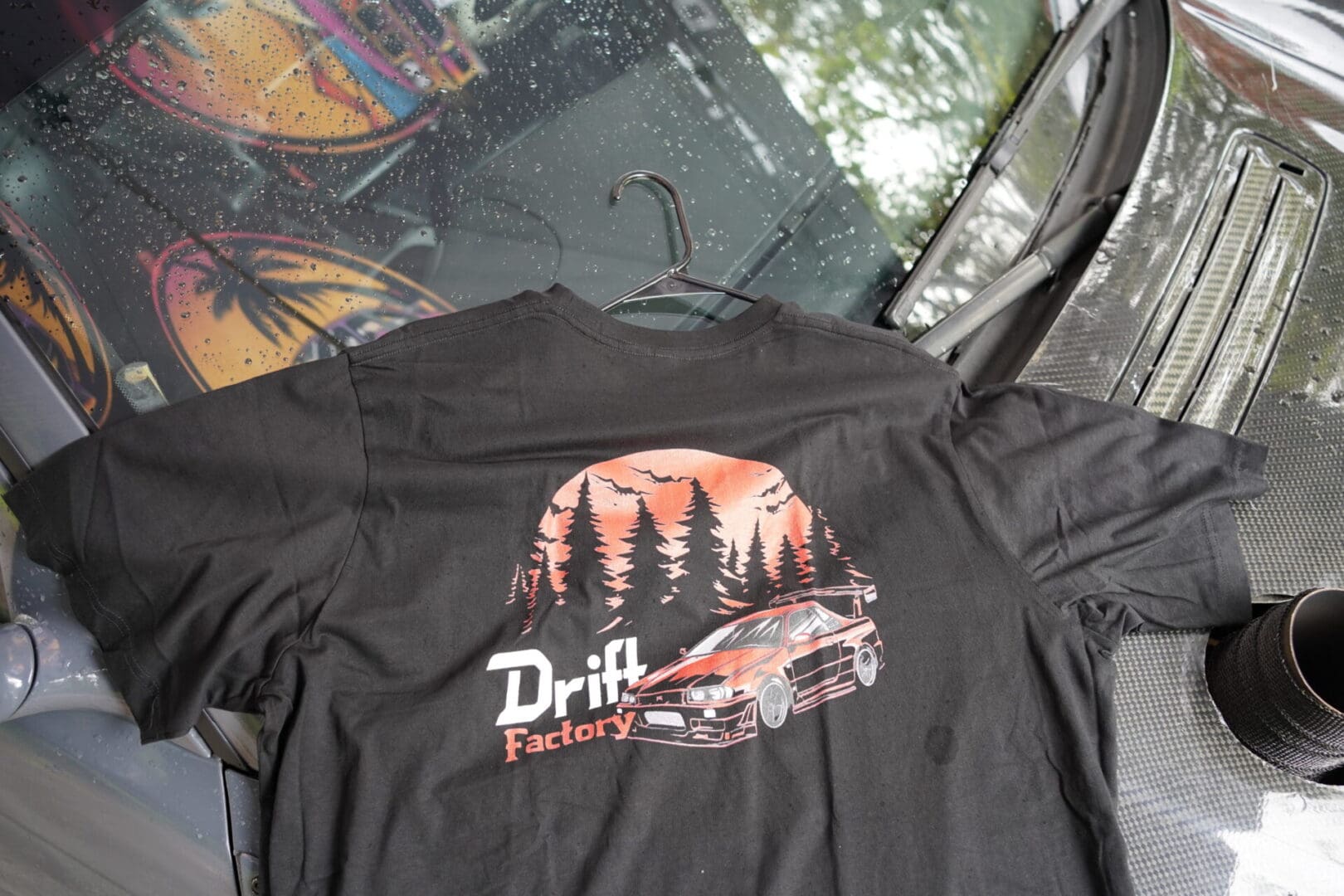 A black shirt with trees and a car on it