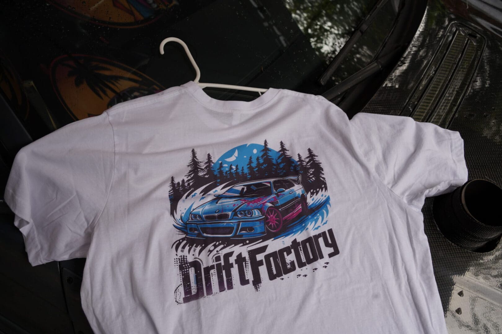 A white shirt with a picture of a car on it.