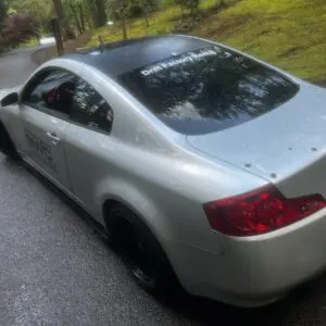 A silver car is parked on the side of the road.