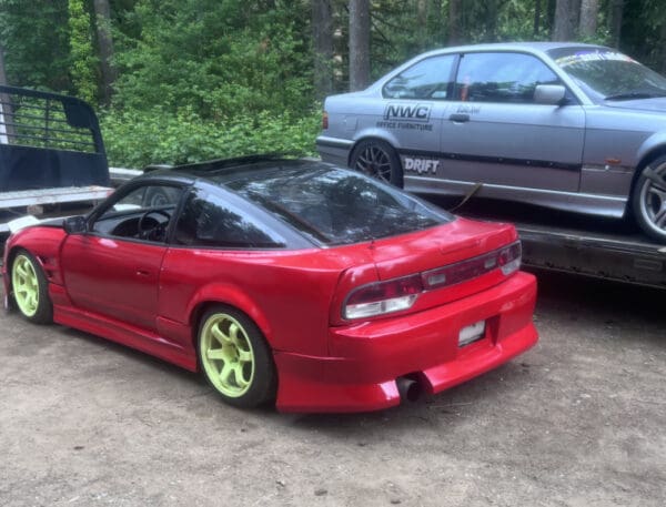 A red car parked in front of another car.