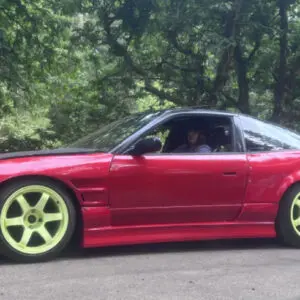 A red car is parked on the side of the road.