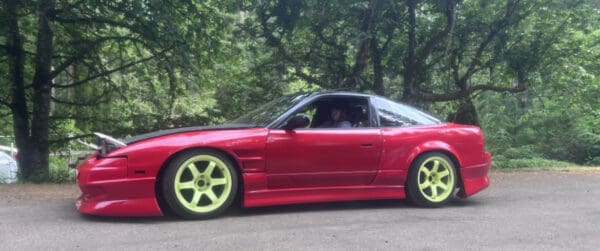 A red car is parked on the side of the road.